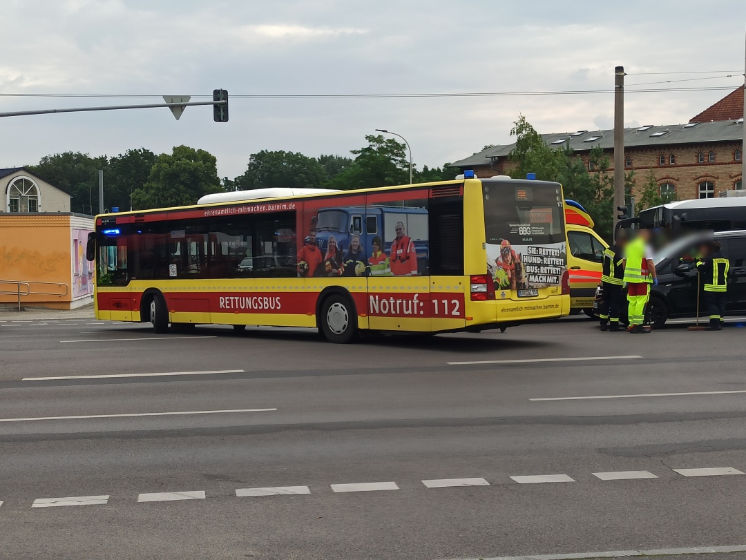 Der Rettungsbus beim Abbiegen in den Kupferhammerweg zu seinem angwiesenen Stellplatz, dahinter beruhigen Einsatzkräfte einen aufgeregten, ungeduldigen PKW-Fahrer