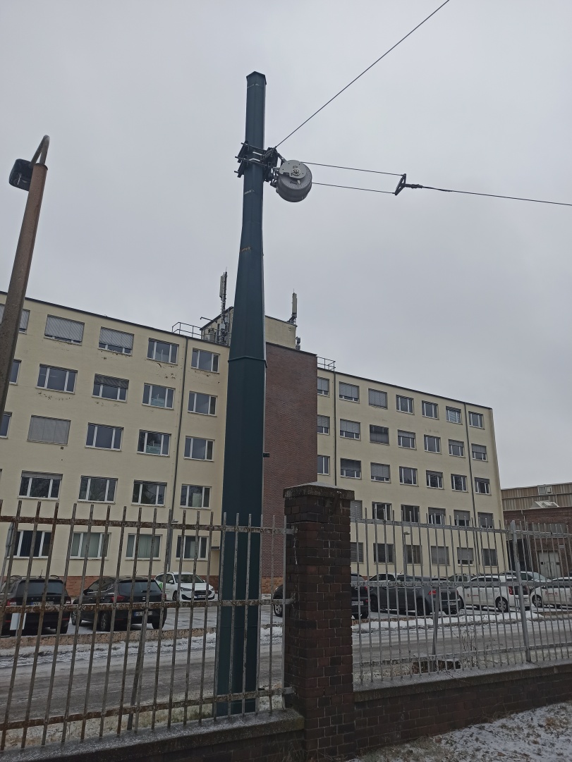 Befestigung der Fahrleitung am Federspanner TENSOREX C+, im Hintergrund ein Gebäude des ehemaligen Kranbau Eberswalde